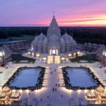 Aerial view of the Swaminarayan Akshardham Temple in Robbinsville, New Jersey, showcasing the grand marble Mahamandir and landscaped gardens under clear blue skies