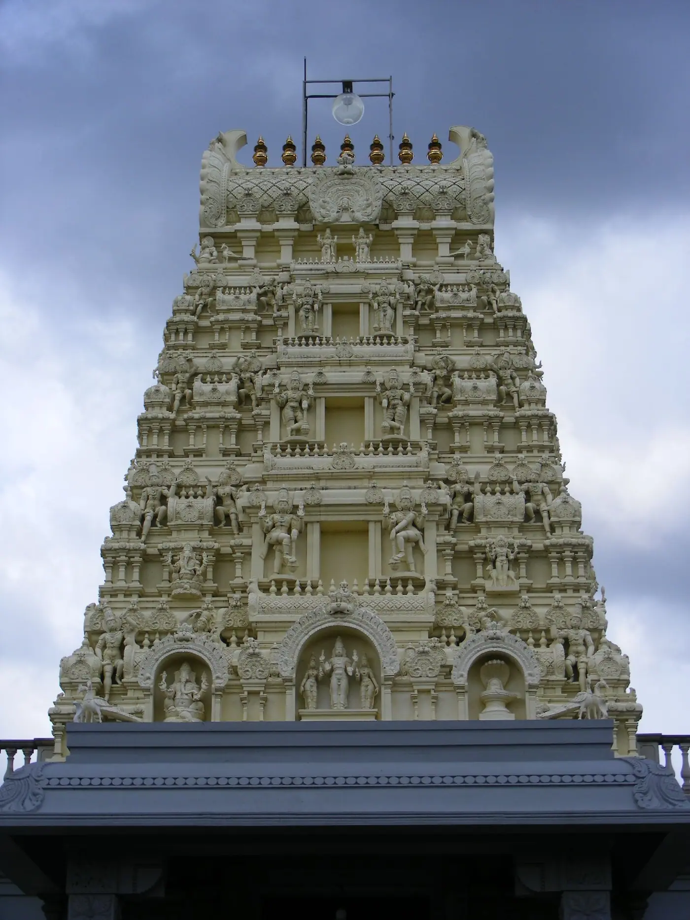 Gopuram tower of the London Sri Murugan Temple in Manor Park, with Murugan, Ganesha and a Shiva lingam in niches at the base