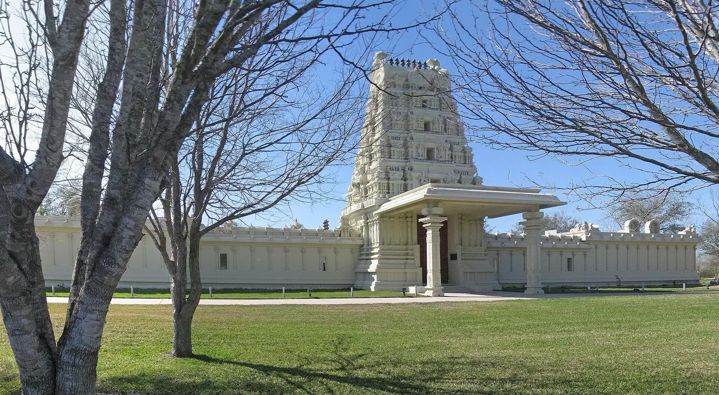 Gopuram entrance and compound wall of Sri Meenakshi Devasthanam temple near Pearland, Texas, seen through bare trees