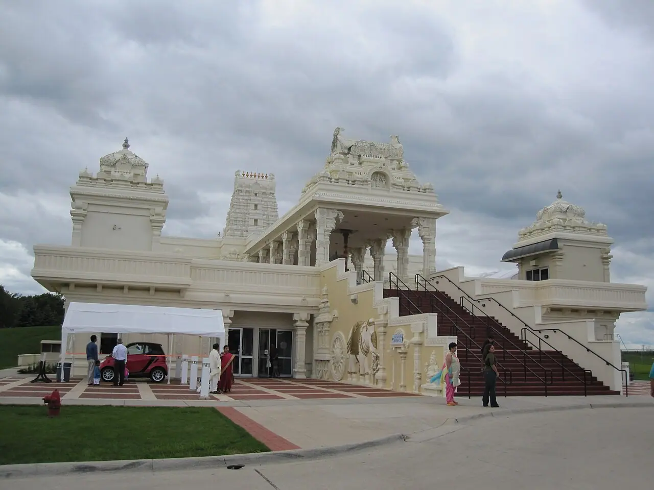 Front of the Sri Venkateswara Swami (Balaji) Temple in Aurora, Illinois, with its cream-coloured gopuram, entrance stairs and carved elephant relief under a cloudy sky